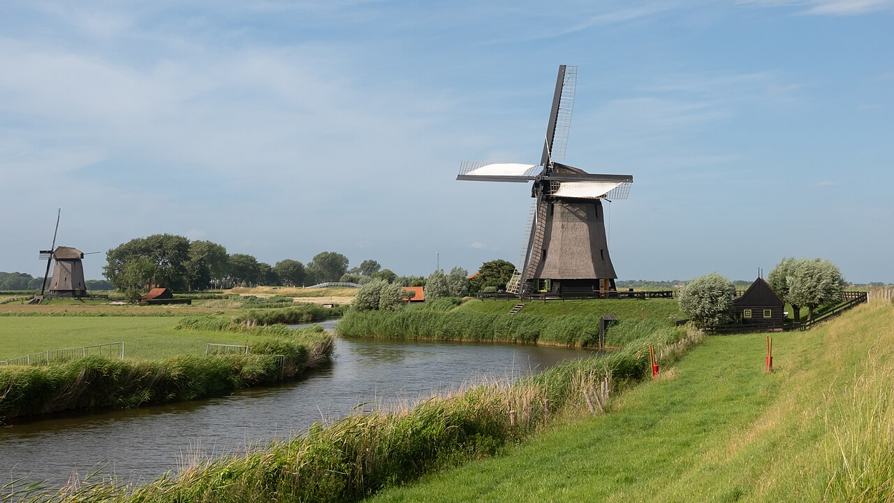 Twee molens aan een water in het Noord-Hollandse polderlandschap